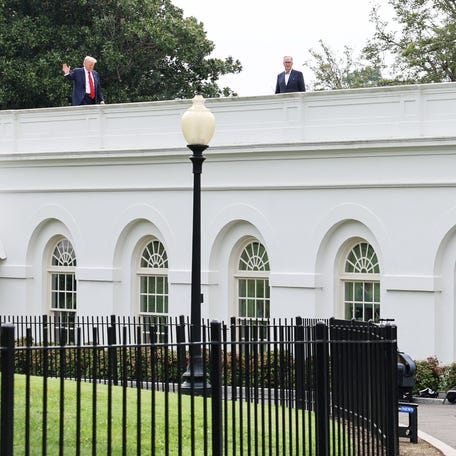 President Donald Trump waves from the roof as he gets a different view of the site of the proposed ballroom, at the White House in Washington, D.C., U.S., August 5, 2025. REUTERS/Jessica Koscielniak