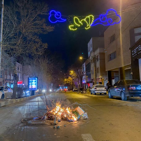Burning debris lies in the middle of a street during unrest in Hamedan, Iran on January 1, 2026. The demonstrations erupted after shopkeepers in Tehran's Grand Bazaar shut their businesses to protest the sharp fall of Iran's currency and worsening economic conditions, with clashes reported in several provinces and Iranian media and rights groups saying multiple people were killed in the violence, marking the largest protests to hit the Islamic Republic in three years.