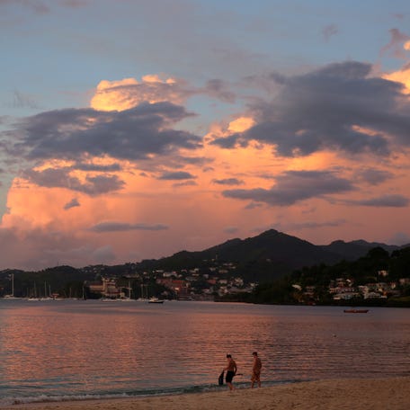 Divers walk into the water of the Caribbean Sea at Grand Anse Beach in St. George's, Grenada on Nov. 27, 2016.