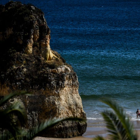 People are pictured at Alvor beach, Portimao,in Algarve, south of Portugal,on May 17, 2021.