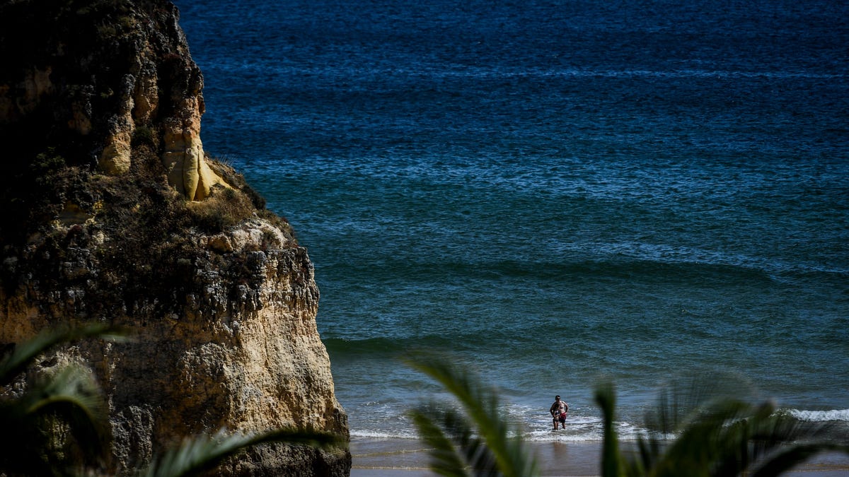 People are pictured at Alvor beach, Portimao,in Algarve, south of Portugal,on May 17, 2021.
