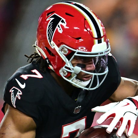 TAMPA, FLORIDA - DECEMBER 11: Kirk Cousins #18 hands off to Bijan Robinson #7 of the Atlanta Falcons during the first quarter at Raymond James Stadium on December 11, 2025 in Tampa, Florida. (Photo by Julio Aguilar/Getty Images)