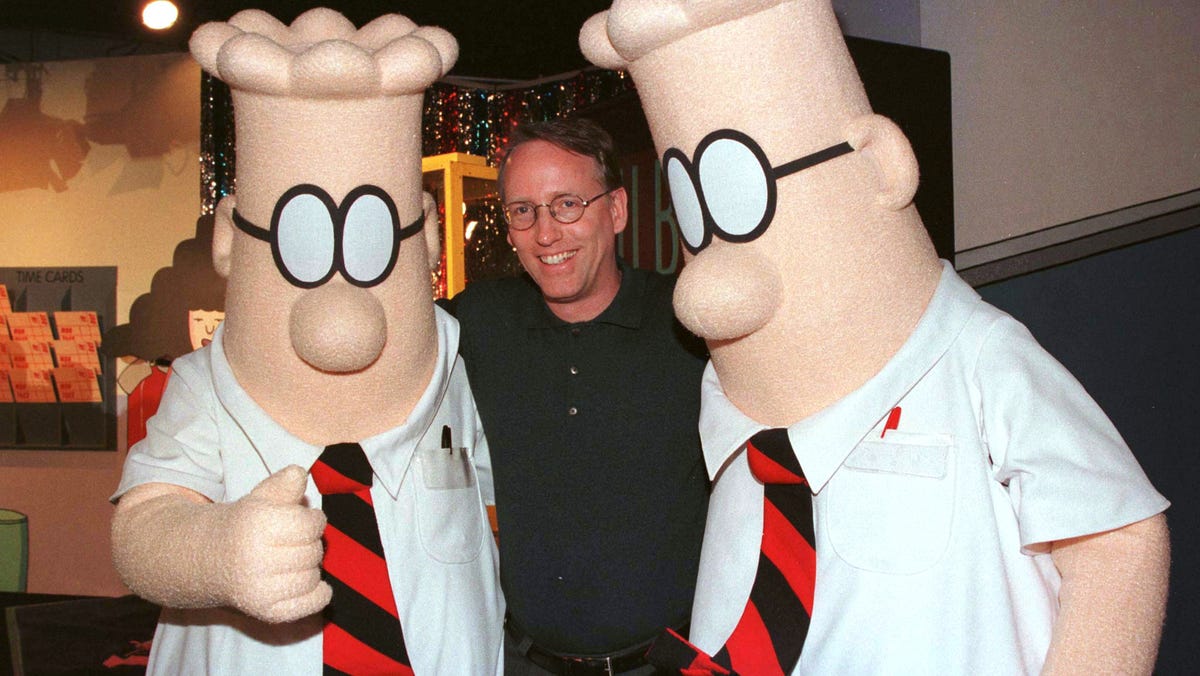Scott Adams, the creator of "Dilbert," poses with two "Dilbert" characters at a party in Pasadena, California, on Jan. 8, 1999 in Pasadena.