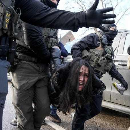 Federal agents carry away a woman in Minneapolis on Jan. 13, 2026, days after an Immigration and Customs Enforcement agent fatally shot Renee Nicole Good.