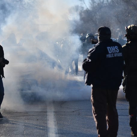 ICE and other federal officers deploy non-lethal munitions during protests as ICE operates in a residential neighborhood in Minneapolis, Minnesota, on January 13, 2026. Hundreds more federal agents were heading to Minneapolis, the US homeland security chief said on January 11, brushing aside demands by the Midwestern city's Democratic leaders to leave after an immigration officer fatally shot a woman protester. In multiple TV interviews, US Homeland Secretary Kristi Noem defended the actions of the   officer who shot and killed 37-year-old Renee Nicole Good, whose death has sparked renewed protests nationwide against President Donald Trump's immigration crackdown. (Photo by Octavio JONES / AFP via Getty Images)