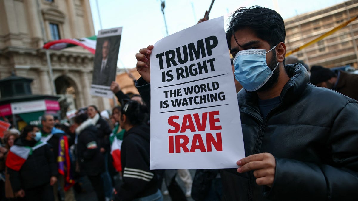 A man shows a sign mentioning U.S. President Donald Trump during a rally in support of nationwide protests in Iran, in Rome, Italy, on Jan. 13, 2026.