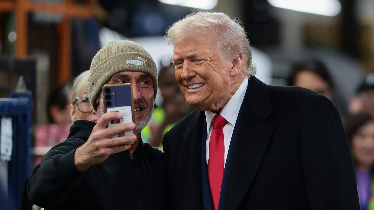 President Donald Trump poses for a photo with a worker at a Ford production center in Dearborn, Michigan, on Jan. 13, 2026.