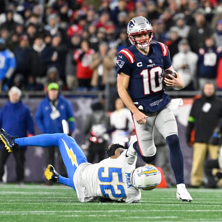 New England Patriots quarterback Drake Maye (10) breaks a tackle by Los Angeles Chargers linebacker Khalil Mack (52) and runs the ball during the first half in an AFC Wild Card Round game at Gillette Stadium on Jan. 11, 2026, in Foxborough, Mass.