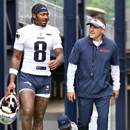 New England Patriots wide receiver Stefon Diggs (8) and offensive coordinator Josh McDaniels walk to the practice fields at Gillette Stadium on June 9, 2025, in Foxborough, Mass.
