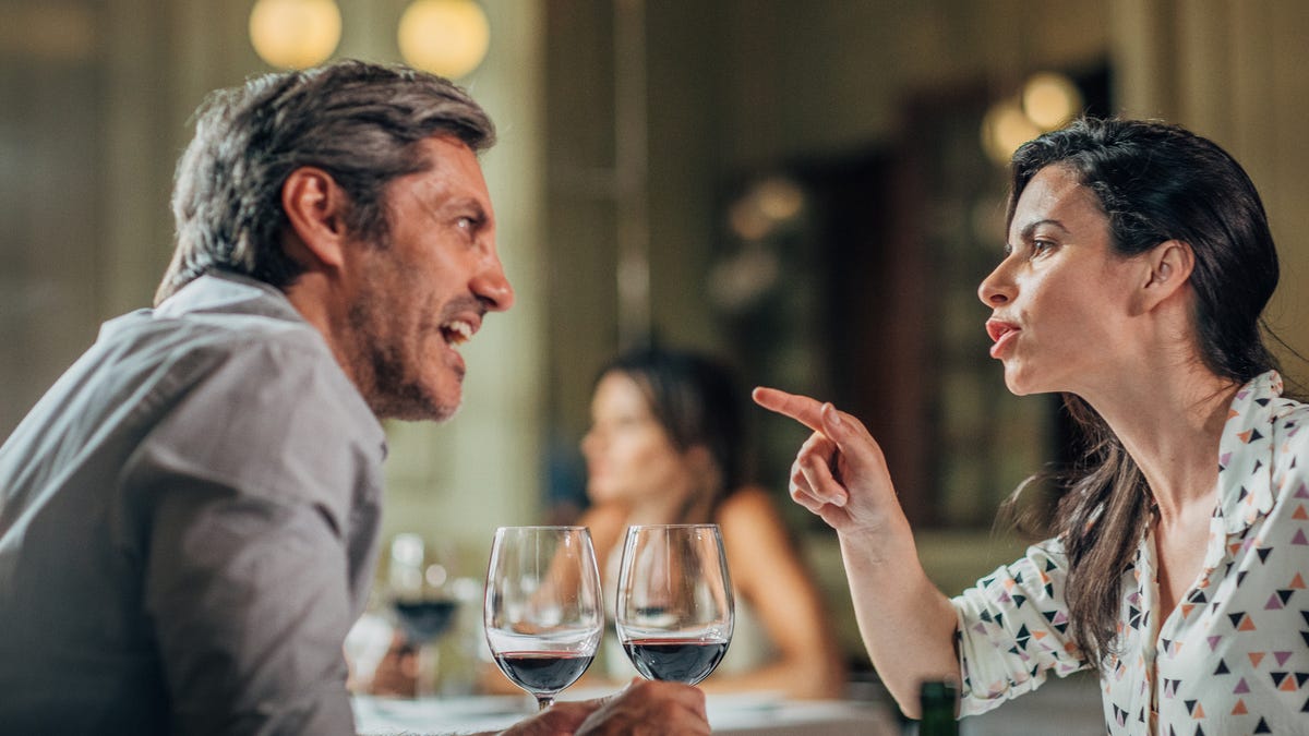 Mature heterosexual couple arguing on a date in restaurant