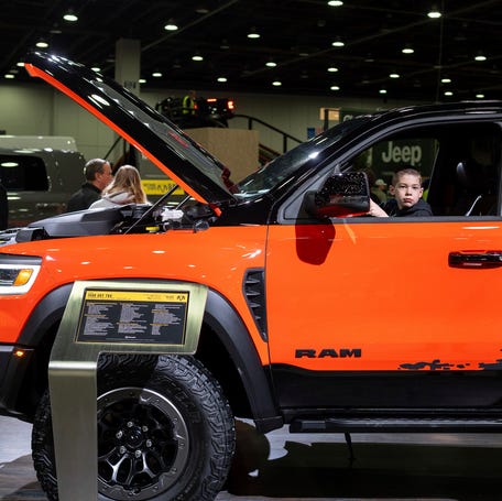 Rob Caudill's son sits on the driver side of a Dodge Ram truck during the first public day of the 2026 Detroit Auto Show inside Huntington Place in Detroit on Saturday, Jan. 17, 2026.