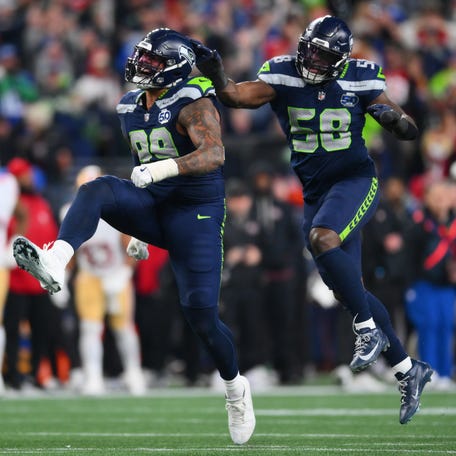 Jan 17, 2026; Seattle, WA, USA; Seattle Seahawks defensive end Leonard Williams (99) and linebacker Derick Hall (58) reacts after the sack of San Francisco 49ers quarterback Brock Purdy (13) during the second half in an NFC Divisional Round game at Lumen Field. Mandatory Credit: Steven Bisig-Imagn Images