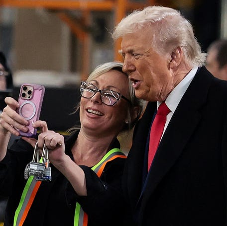 President Donald Trump poses for a photo with a worker as he visits a Ford production center in Dearborn, Michigan, on Jan. 13, 2026.