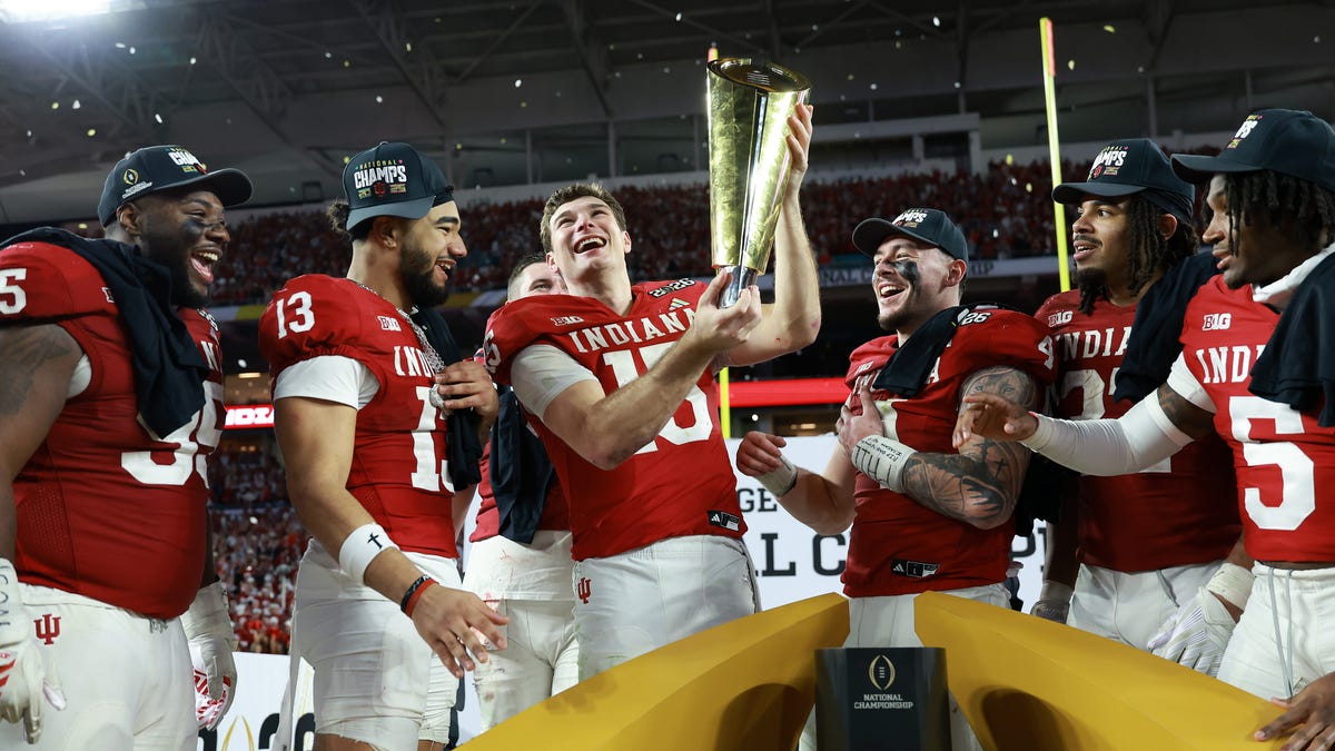 Jan 19, 2026; Miami Gardens, FL, USA; Indiana Hoosiers quarterback Fernando Mendoza (15) reacts with the trophy after the College Football Playoff National Championship game at Hard Rock Stadium. Mandatory Credit: Mark J. Rebilas-Imagn Images