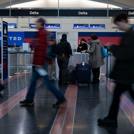 ARLINGTON, VIRGINIA - DECEMBER 23: Travelers pass through Ronald Reagan Washington National Airport on December 23, 2025 in Arlington, Virginia.