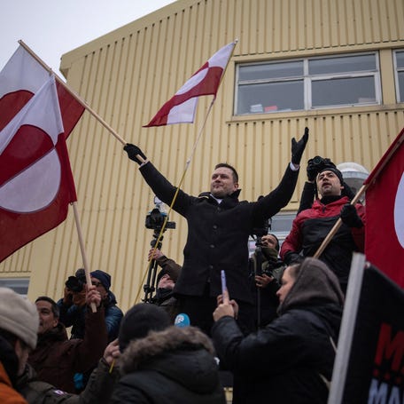 Greenland's prime minister, Jens-Frederik Nielsen, waves the Greenlandic flag during a protest against President Donald Trump in Nuuk on Jan. 17, 2026.