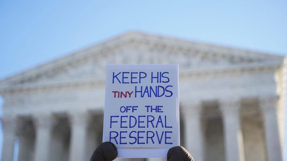 A person holds a placard in front of the U.S. Supreme Court as the justices consider U.S. President Donald Trump's effort to fire Federal Reserve Governor Lisa Cook, in Washington, D.C., U.S., January 21, 2026.
