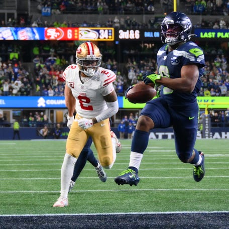 Jan 17, 2026; Seattle, WA, USA; Seattle Seahawks running back Kenneth Walker III (9) carries the ball for a touchdown as San Francisco 49ers cornerback Deommodore Lenoir (2) trails on the play during the second half in an NFC Divisional Round game at Lumen Field. Mandatory Credit: Steven Bisig-Imagn Images