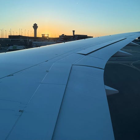 A watch tower stands in the distance of an American Airlines aircraft wing at Chicago's O'Hare International Airport on Oct. 8, 2025.