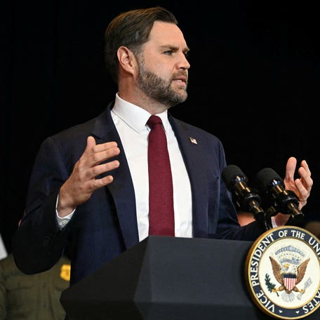 An ICE vehicle sits in the background as federal immigration agents listen to Vice President JD Vance speak at Royalston Square in Minneapolis on Jan. 22, 2026.
