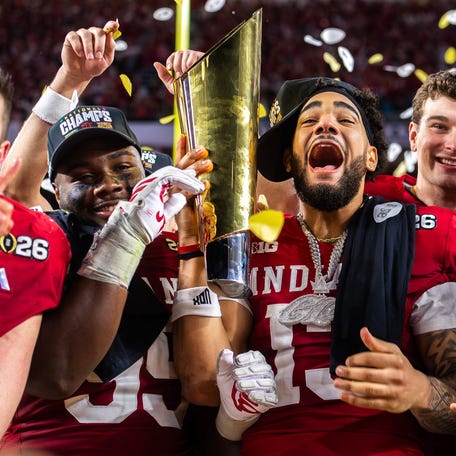 Indiana's Pat Coogan (78), Tyrique Tucker (95), Elijah Sarratt (13) and Fernando Mendoza (15) celebrate with the trophy after the College Football Playoff National Championship college football game at Hard Rock Stadium in Miami Gardens on Monday, Jan. 19, 2026.