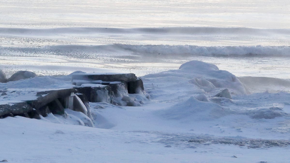 A lakefront jetty is encased in ice and snow, Friday, Jan. 23, 2026, in Sheboygan, Wisconsin.