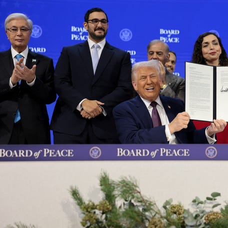 U.S. President Donald Trump, alongside Kazakhstan's President Kassym-Jomart Tokayev, Bahrain's Minister of the Prime Minister's Court Shaikh Isa bin Salman bin Hamad Al Khalifa, Pakistan's Prime Minister Shehbaz Sharif, Kosovo's President Vjosa Osmani, and Morocco's Foreign Minister Nasser Bourita, takes part in a charter announcement for his Board of Peace initiative aimed at resolving global conflicts, alongside the 56th annual   World Economic Forum (WEF), in Davos, Switzerland, January 22, 2026. REUTERS/Jonathan Ernst