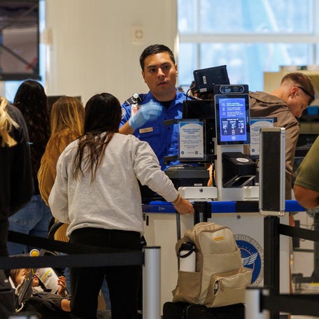 A TSA agent checks travelers at San Diego International Airport on November 7, 2025.