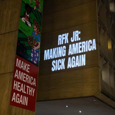Activists with Protect Our Care shines light on the growing measles crisis with a projection on the U.S. Department of Health and Human Services on Jan. 20, 2026, in Washington, DC.