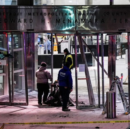 Workers clean up damage near the international ticketing gate of Detroit Metro Airport McNamara Terminal after a car drove into the building in Romulus on Friday, Jan. 23, 2026.