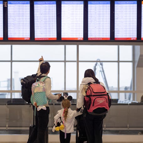 People check the flight tracker screens at the Dallas Fort Worth International Airport in Fort Worth, Texas on January 23, 2026.