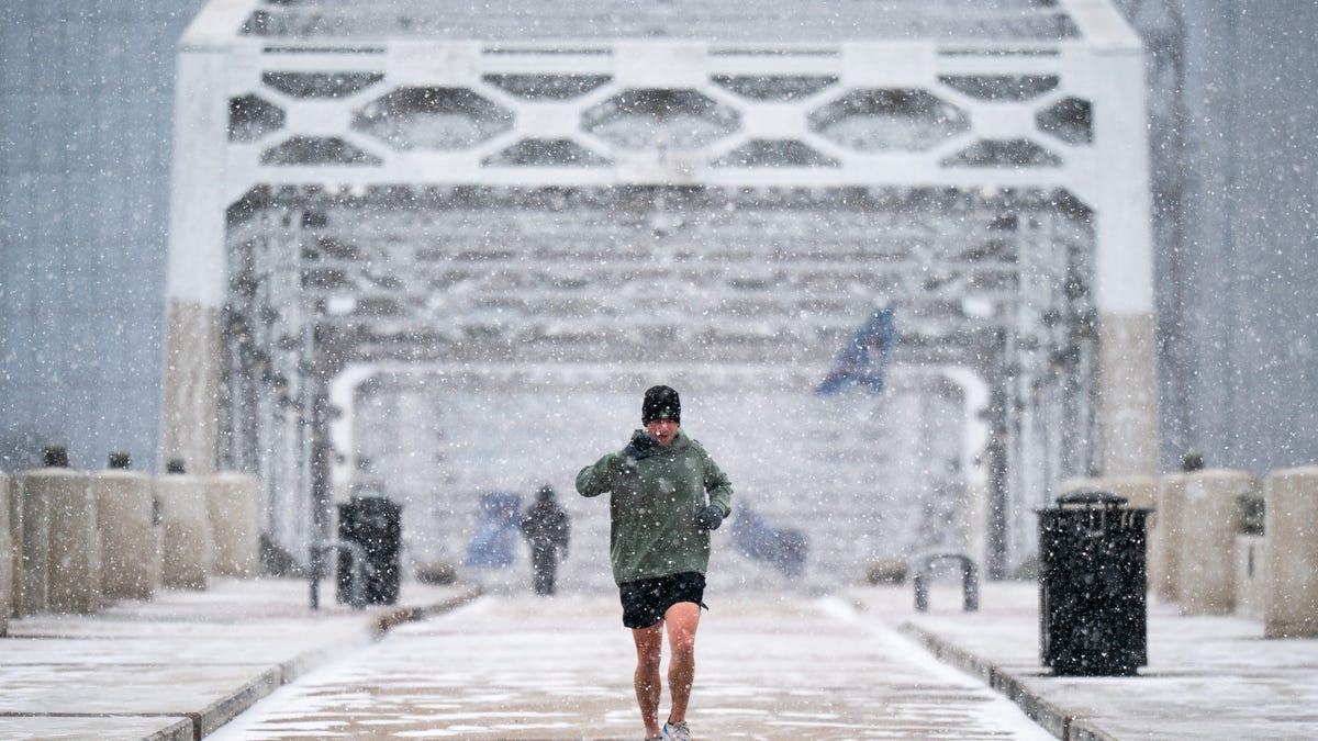 Tommy Baird jogs on the John Seigenthaler Pedestrian Bridge as snow falls in Nashville, Tenn., Saturday, Jan. 24, 2026. A winter storm brought snow and ice to Middle Tennessee on Saturday.