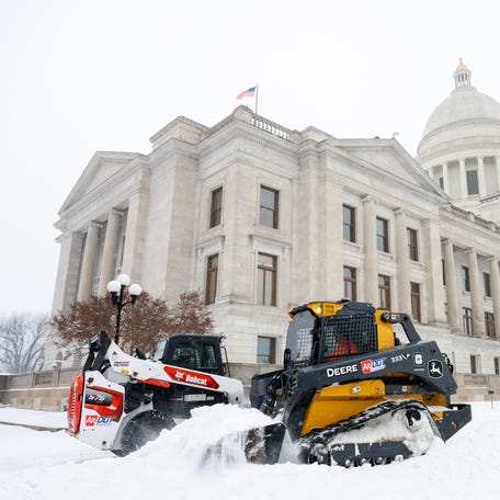 Workers move snow at the Arkansas State Capitol on January 24, 2026 in Little Rock, Arkansas.