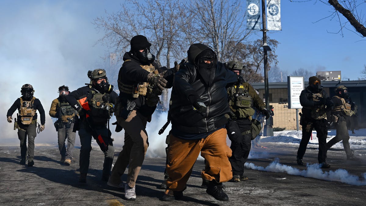 A person is chased by federal agents amid protests following a shooting on January 24, 2026 in Minneapolis, Minnesota.