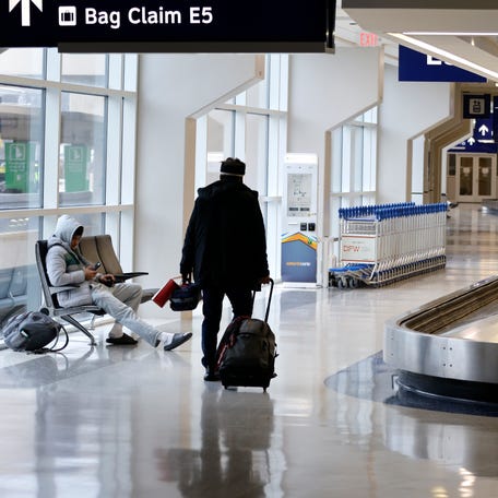 Passengers walk through Terminal E at Dallas Fort Worth International Airport on January 24, 2026 in Dallas, Texas.