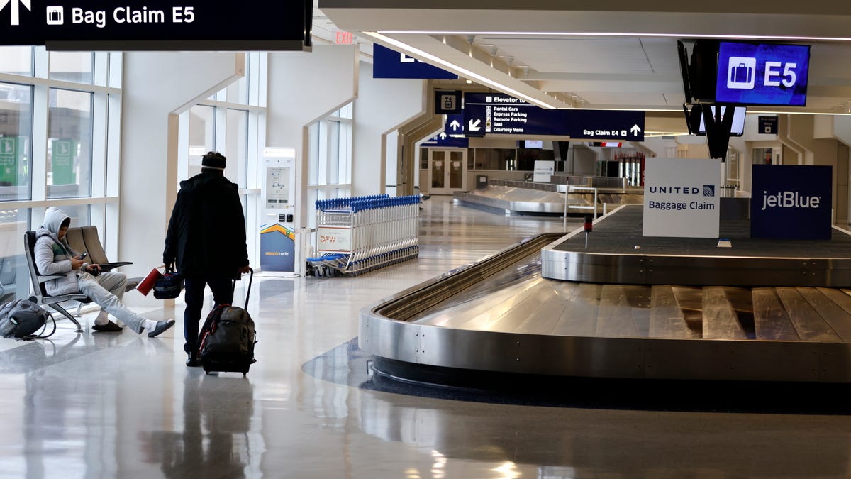 Passengers walk through Terminal E at Dallas Fort Worth International Airport on January 24, 2026 in Dallas, Texas.