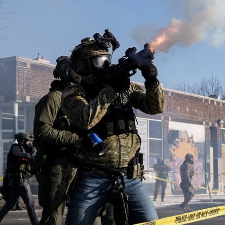 A federal agent shoots tear gas cannisters during clashes with community members at the scene where federal agents fatally shot a man while trying to detain him, in Minneapolis, Minnesota, U.S., January 24, 2026.