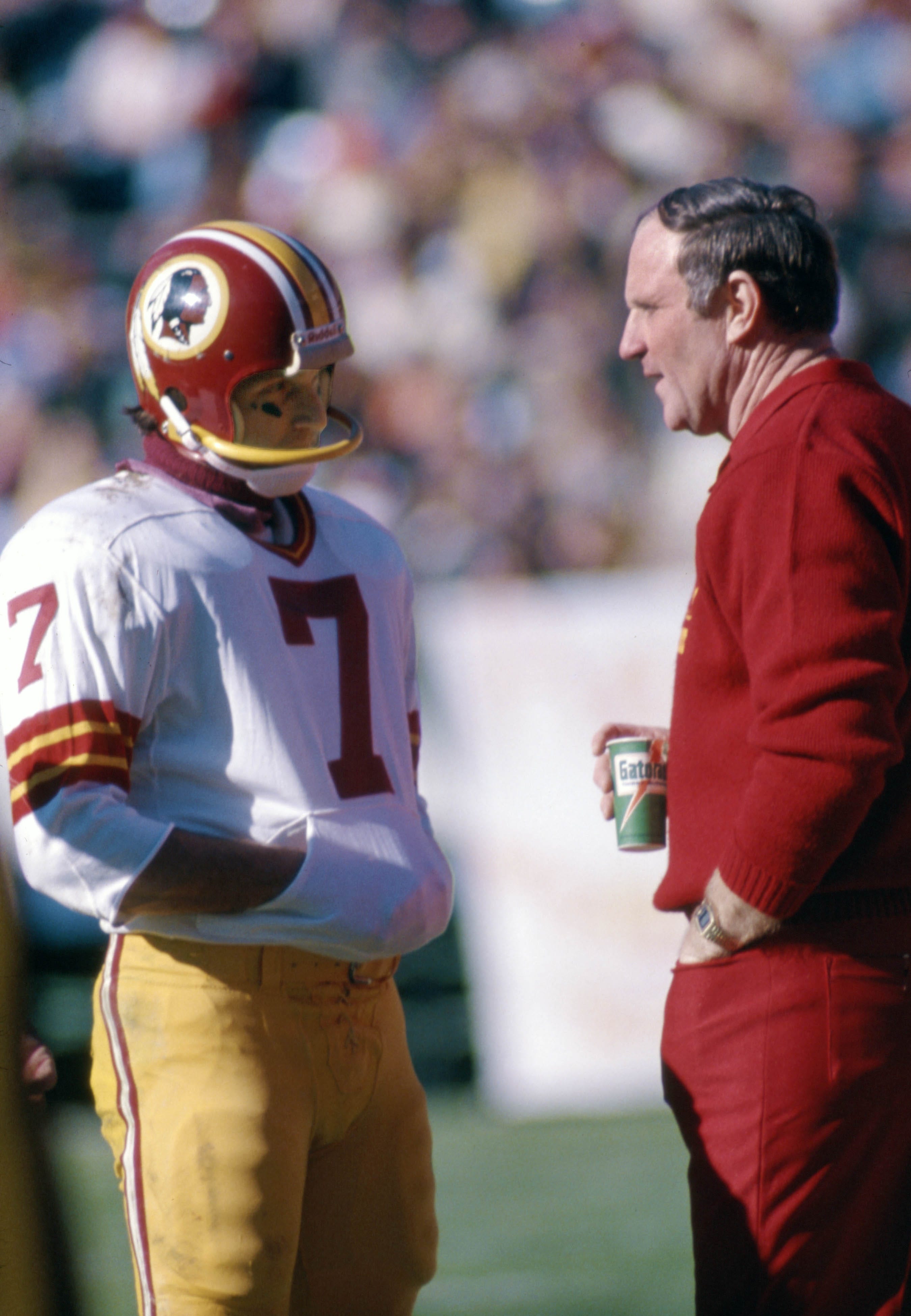 Washington quarterback Joe Theismann talks with head coach Jack Pardee on the sideline against the Atlanta Falcons at Fulton County Stadium.