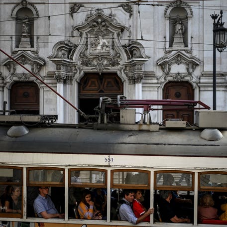 Passengers take a tram ride at Chiado in Lisbon on October 28, 2022. - While the approximately 7,000 Americans residing in Portugal remain far fewer in number than English or French expatriates, their number doubled between 2018 and 2021, according to the most recent official statistics. (Photo by PATRICIA DE MELO MOREIRA / AFP) (Photo by PATRICIA DE MELO MOREIRA/AFP via Getty Images)