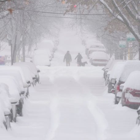 Pedestrians walk through the heavy snow in Columbus as Winter Storm Fern continues to dump snow on Central Ohio on Jan. 25, 2026.