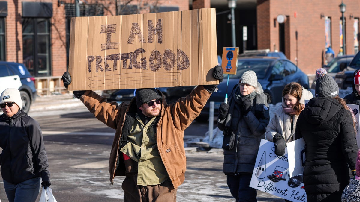 Brady Pearl of Minneapolis on Jan. 25, 2026, carries a sign honoring Alex Pretti and Renee Good, two local residents who died at the hands of federal immigration officers in January during a series of protests.