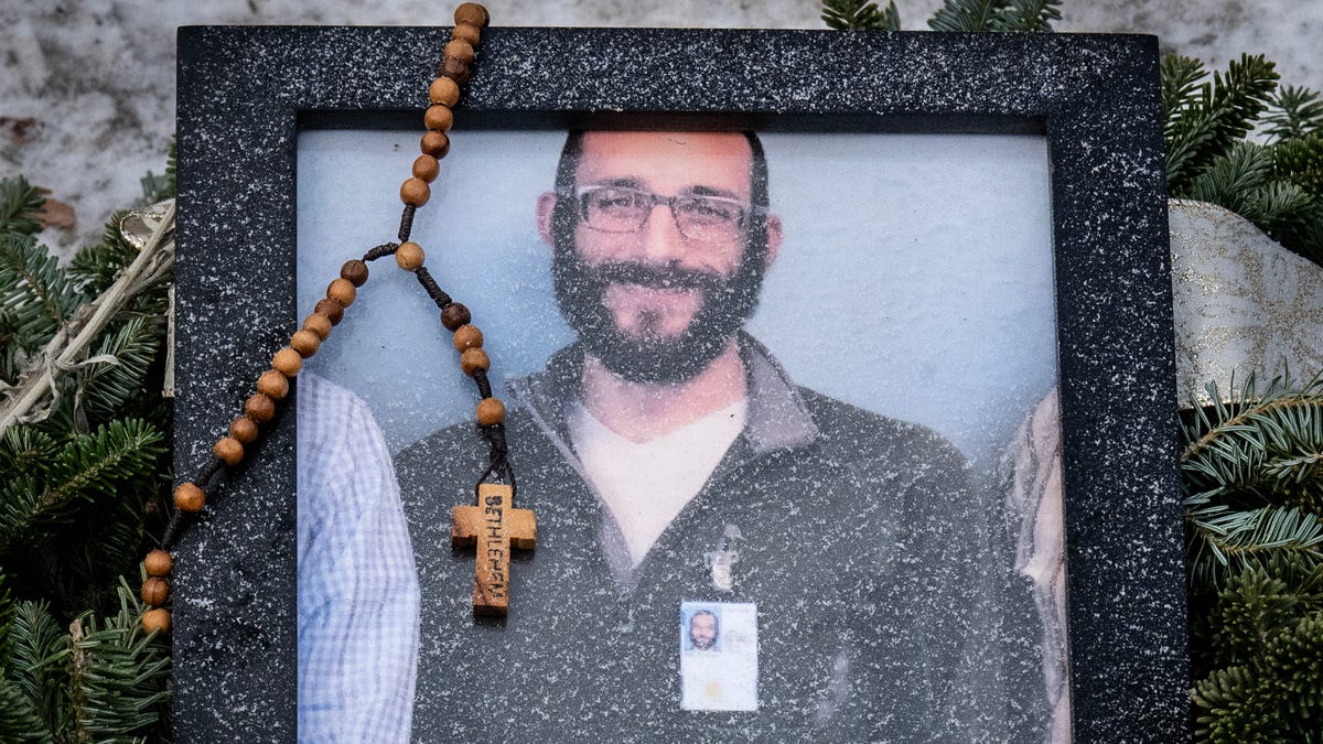 A rosary adorns a framed photo Alex Pretti that was left at a makeshift memorial in Minneapolis, Minnesota, on Jan. 25, 2026.