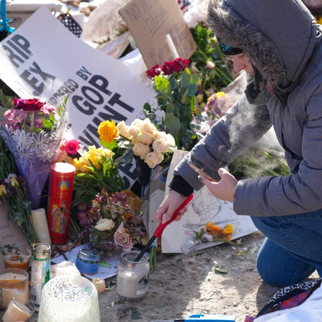 Mourners pay their respects at a memorial site on Nicolett Avenue in Minneapolis marking where Alex Pretti was shot and killed by federal immigration agents.