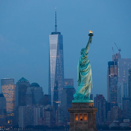The Statue of Liberty stands in the foreground as Lower Manhattan is viewed at dusk, Sept. 8, 2016 in New York City.