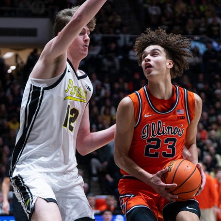 Illinois guard Keaton Wagler (23) dribbles past Purdue center Daniel Jacobsen (12) during their game at Mackey Arena.