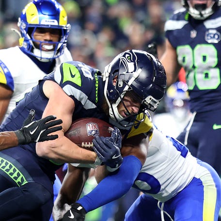 SEATTLE, WASHINGTON - JANUARY 25: Cooper Kupp #10 of the Seattle Seahawks runs through Quentin Lake #37 and Kamren Kinchens #26 of the Los Angeles Rams for a third quarter touchdown in the NFC Championship game at Lumen Field on January 25, 2026 in Seattle, Washington. (Photo by Steph Chambers/Getty Images)
