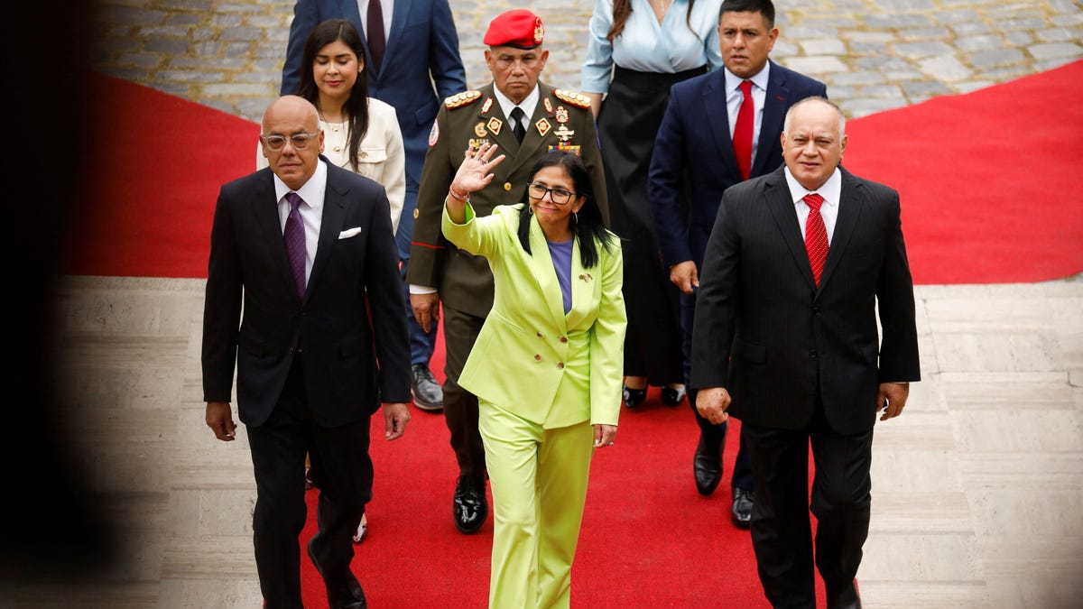 Venezuela's interim president Delcy Rodriguez waves as she walks, next to Venezuela's Interior Minister Diosdado Cabello and National Assembly President Jorge Rodriguez, to deliver her first annual address to the nation at the National Assembly, following the U.S. strike in Caracas that resulted in the capture of President Nicolas Maduro and his wife, Cilia Flores, in Caracas, Venezuela, January 15, 2026. REUTERS/Leonardo   Fernandez Viloria