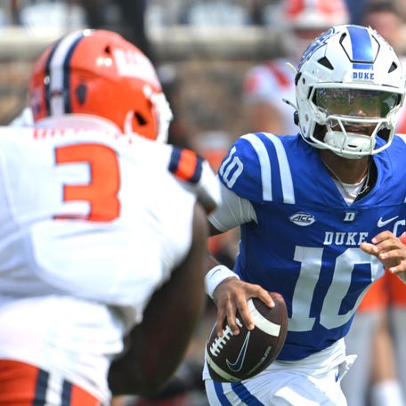 Sep 6, 2025; Durham, North Carolina, USA; Duke Blue Devils quarterback Darian Mensah (10) scrambles against Illinois Fighting Illini linebacker Alec Bryant (3) during the fourth quarter at Wallace Wade Stadium. Mandatory Credit: Zachary Taft-Imagn Images
