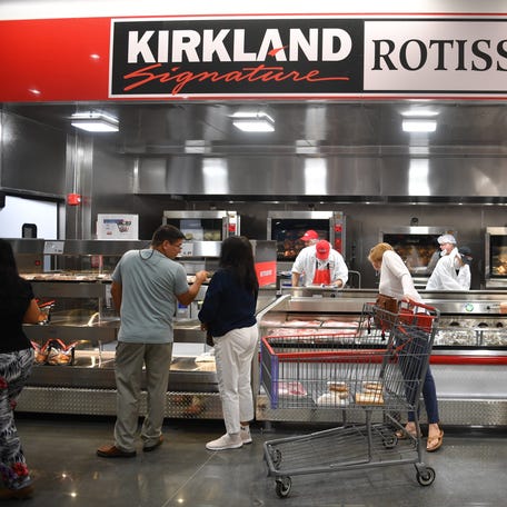 Shoppers walk past the rotisserie chicken counter at a Costco Wholesale store in North Port, Florida during their grand opening on Wednesday, June 5, 2024.