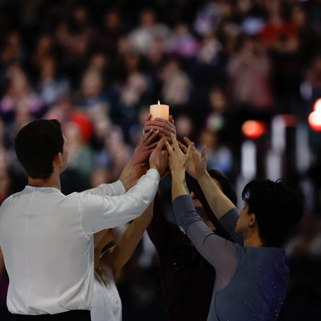 Mar 2, 2025; Washington D.C., USA; Maxim Naumov holds a candle with Alisa Efimova, Misha Mitrofanov, and Jimmy Ma performing a tribute to his parents, Vadim Naumov and Evgenia Shishkova, who died in the Potomac River mid-air collision during the Legacy on Ice benefit to support victims of the tragedy at Ronald Reagan Washington National Airport at Capital One Arena. Mandatory Credit: Geoff Burke-Imagn Images